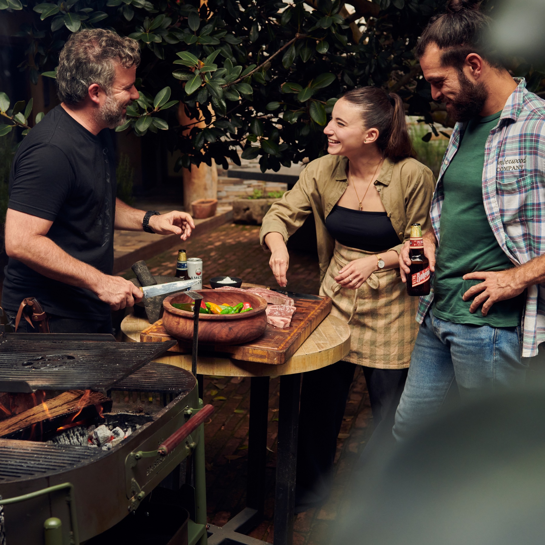 Amigos preparando alimentos alrededor del Asador Sierra Madre