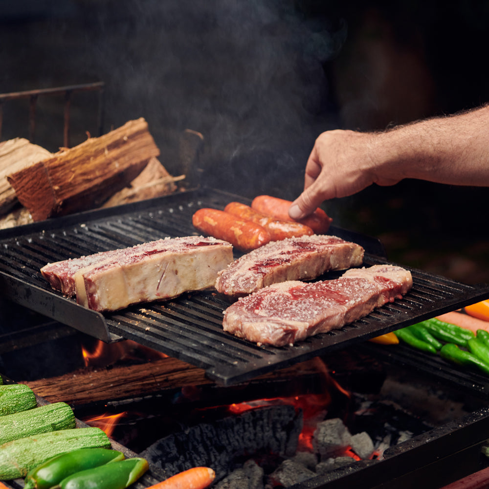 Carne y vegetales cocinándose sobre las distintas zonas del Asador Sierra Madre